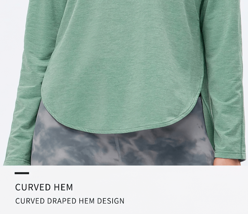 Green sports top with a curved draped hem and full sleeves, designed for yoga and optimal comfort. Ideal for workouts. SF0048.