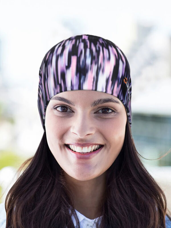 Woman wearing a colorful fashion bicycle beanie cap, ideal for running and cycling, made from breathable quick-dry fabric.