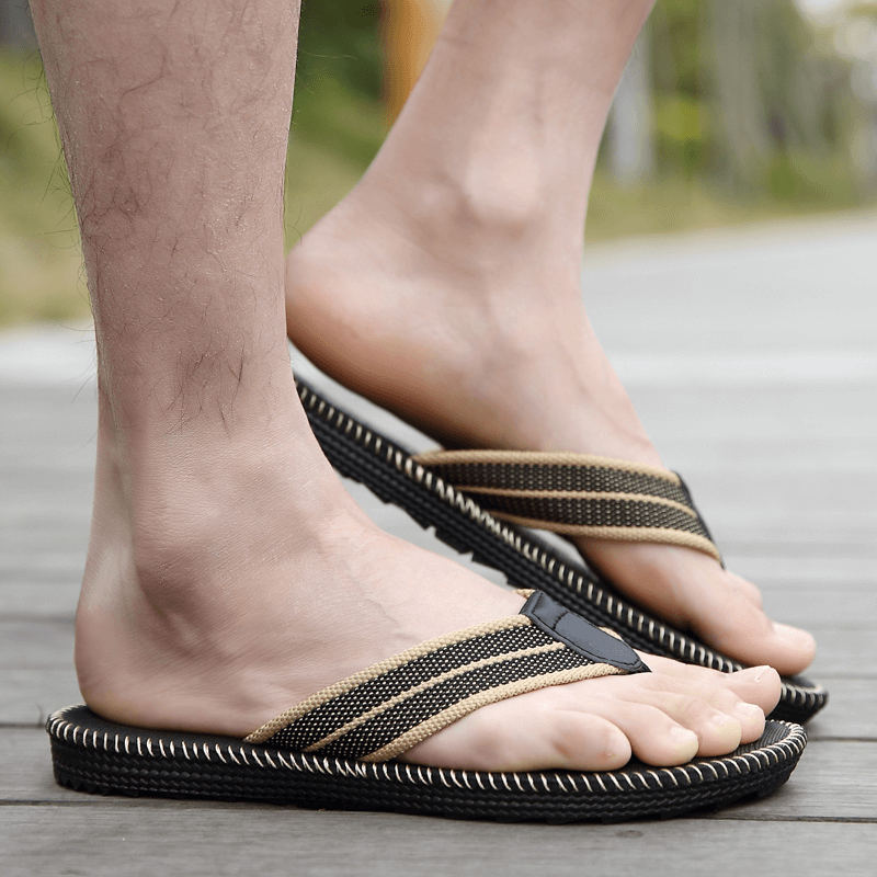 Man wearing Fashion Breathable Lightweight Casual Beach Flip Flops SF1195 on a wooden deck