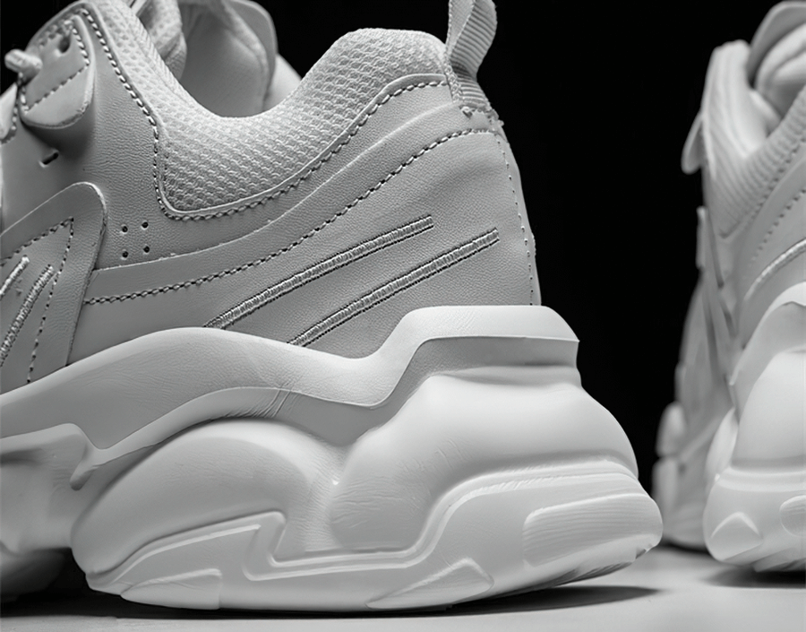 Close-up of stylish white lace-up platform male sneakers with mesh design and cushioned EVA outsole, ideal for modern sports style.