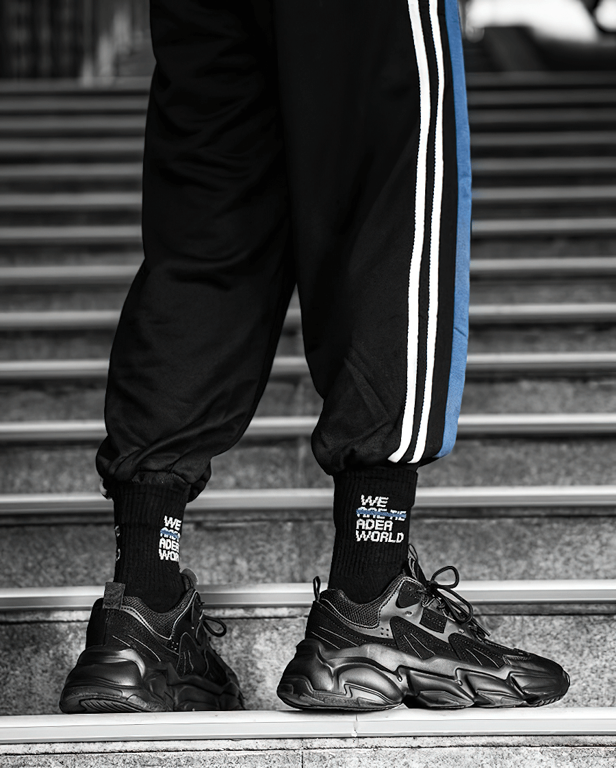 Man wearing black lace-up platform sneakers with mesh design stepping confidently on stairs, fashion-forward and stylish.
