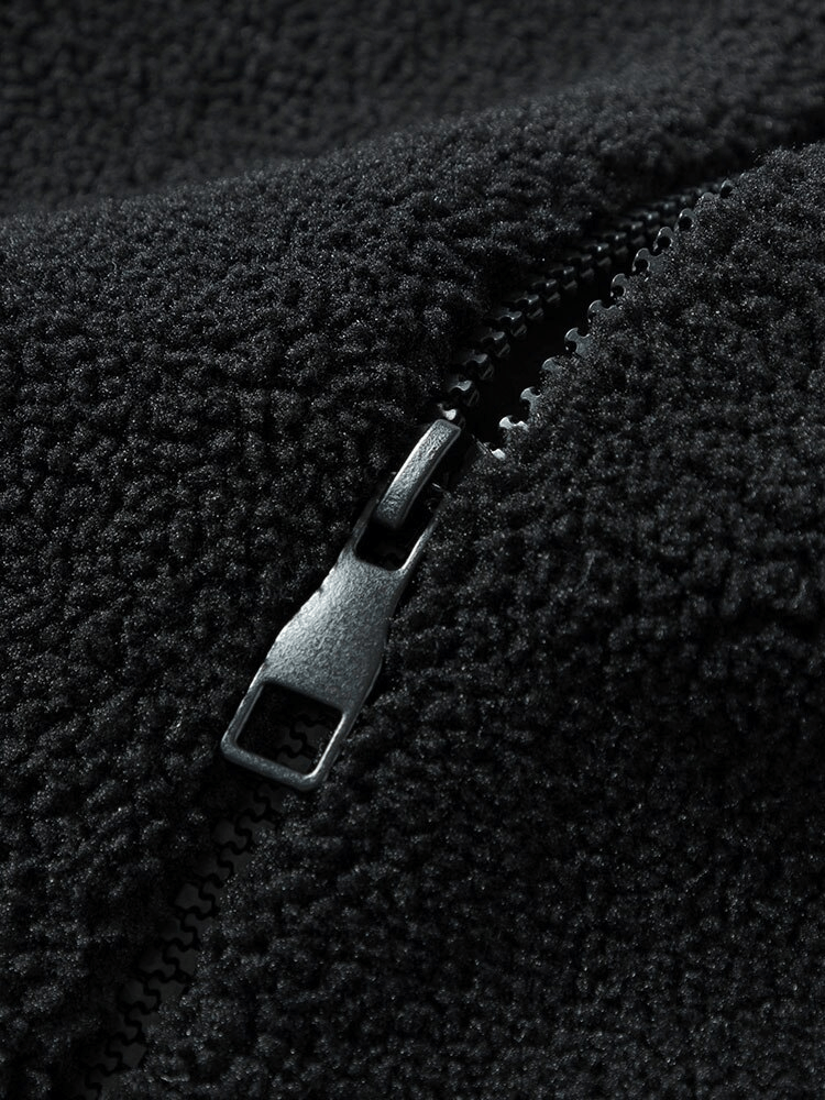 Close-up of a black fleece jacket zipper detail.