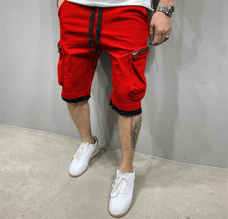 Fashion men's red cotton running shorts with zipper pockets, elastic waistband, paired with white sneakers.