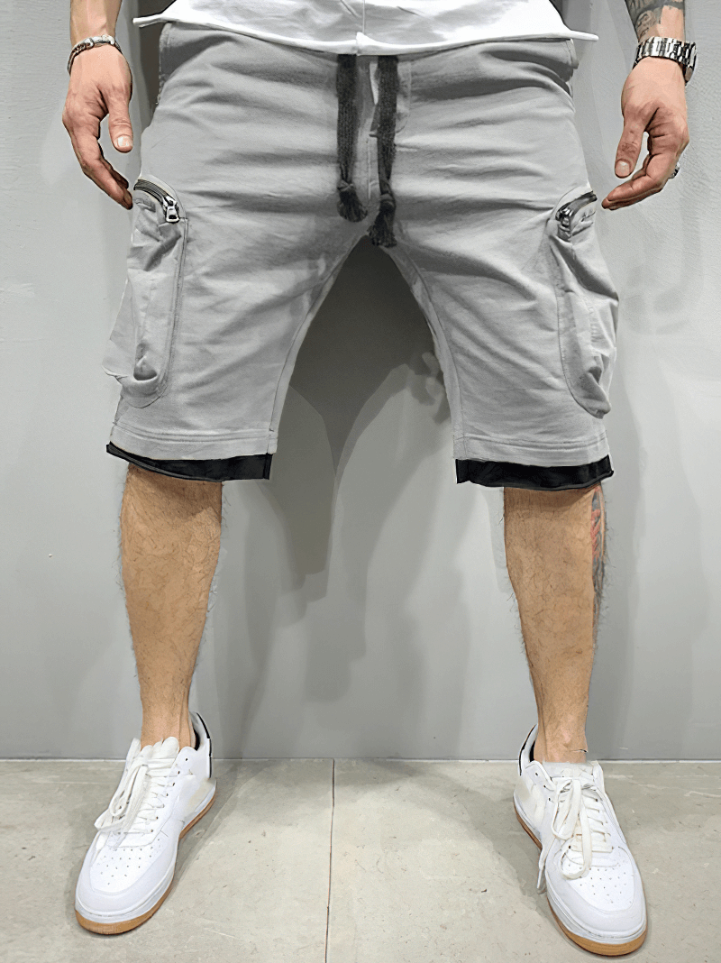 Fashion men's cotton running shorts with zipper pockets, adjustable elastic waistband, shown worn with white sneakers.