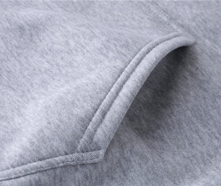 Close-up of a gray men's sweatshirt pocket, showcasing soft fabric and detailed stitching.