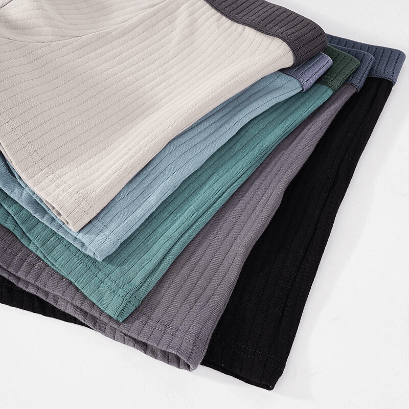 Stack of Fashion Stripe Solid Color Cotton Boxers for Men in various colors, showcasing durable cotton fabric and stylish stripe design.