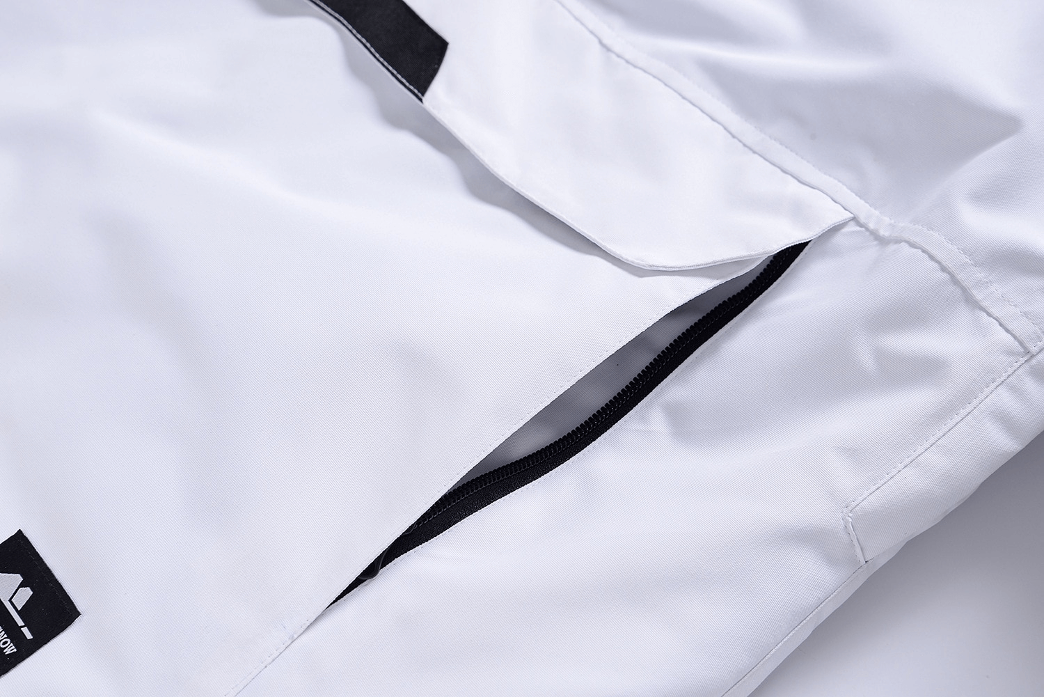 Close-up of a white ski jacket with a zippered pocket, showing waterproof material, perfect for skiing and snowboarding adventures