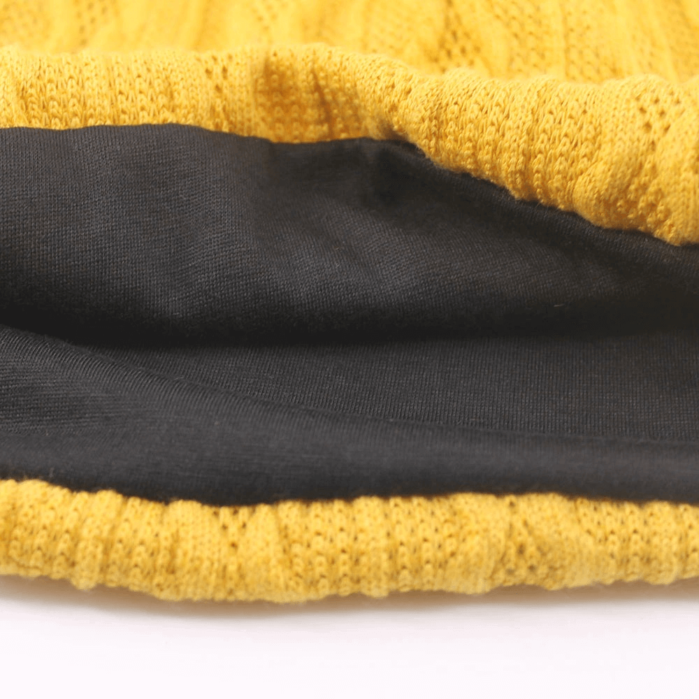 Close-up of a warm knit yellow beanie with a soft black lining, perfect for stylish comfort in chilly weather.