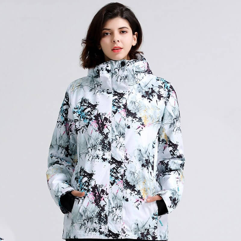 Woman wearing stylish snowboarding jacket, water-resistant, windproof, perfect for skiing. Features vibrant pattern and hooded collar.