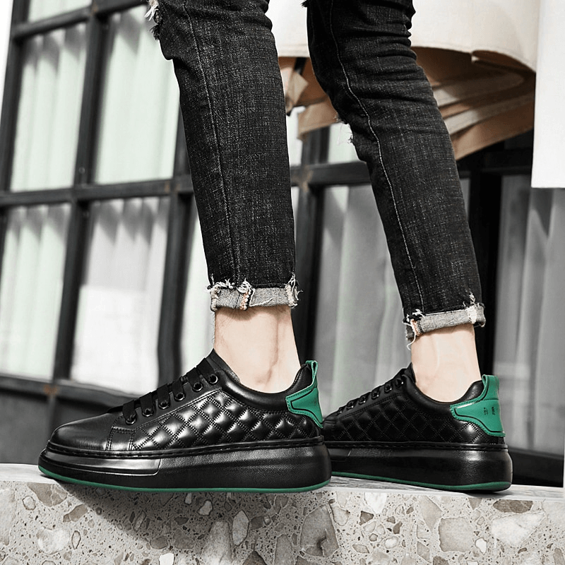 Stylish black and green men's sneakers with genuine leather uppers and rubber outsole for comfort and durability, worn casually.
