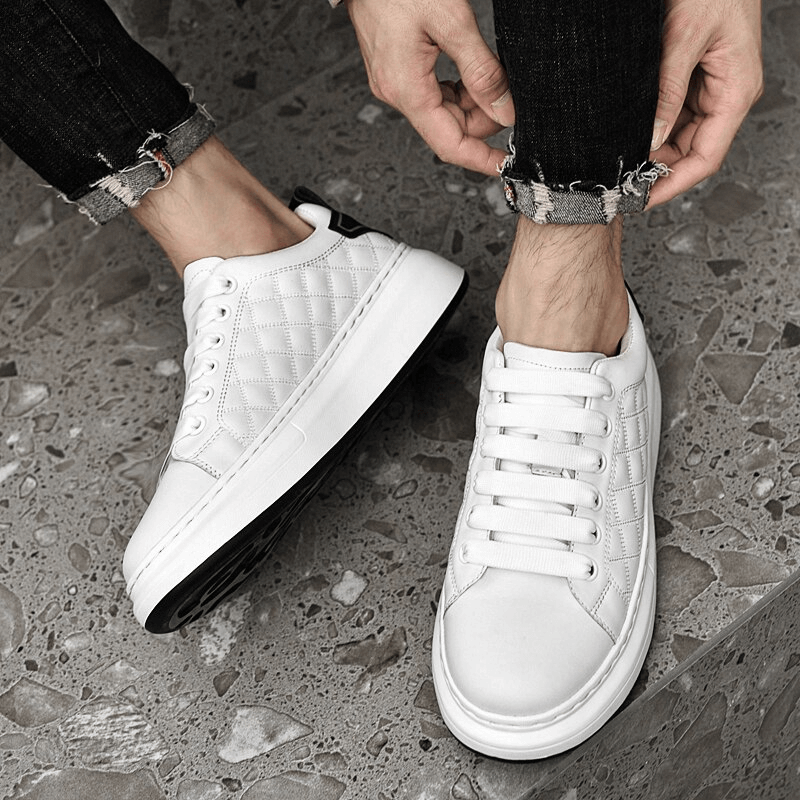 White fashionable breathable men's sneakers with quilted leather design and rubber outsole, perfect for casual style and comfort.