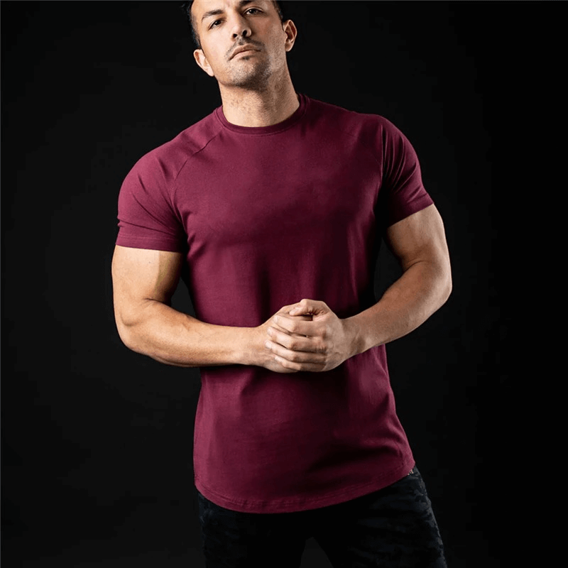 Model wearing a fashionable lightweight sporty men's burgundy T-shirt for training, featuring an O-neck collar and short sleeves.