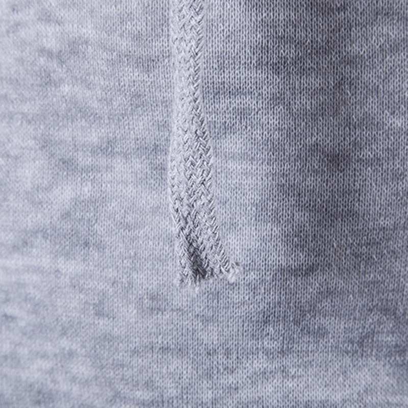 Close-up of light gray fabric texture showing weave pattern on men's vest.