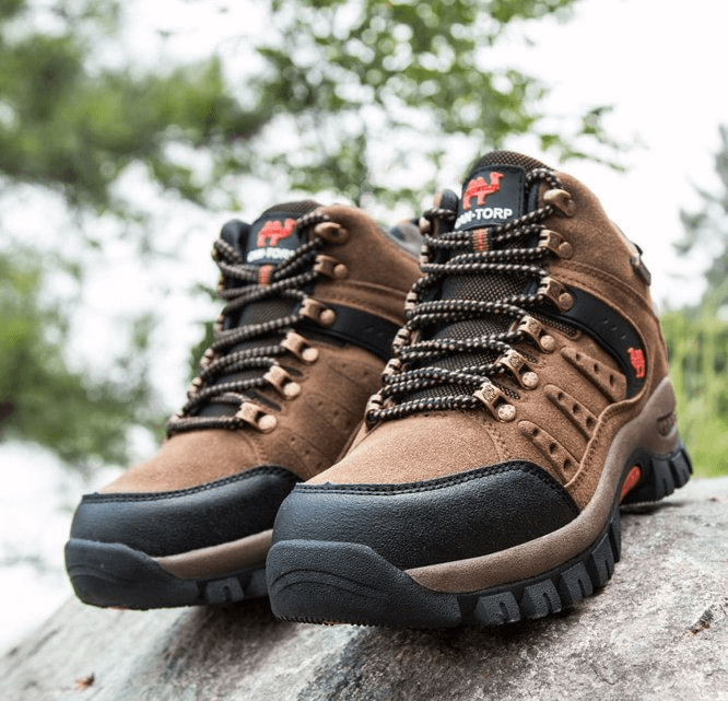 Fashionable waterproof trekking boots SF0814 with brown PU, round toe, and ankle strap on a rock.