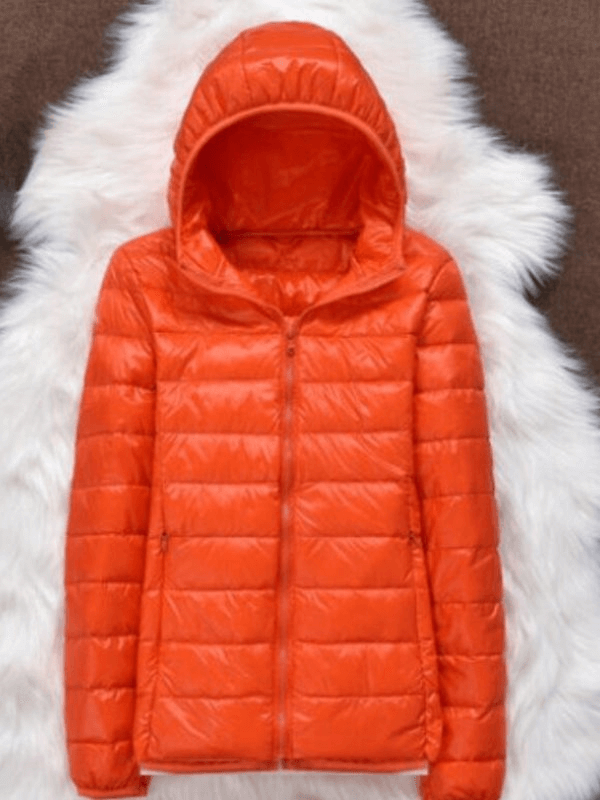 Orange ultralight women's hooded jacket with zipper and pockets, featuring 90% white duck down insulation on a faux fur background.