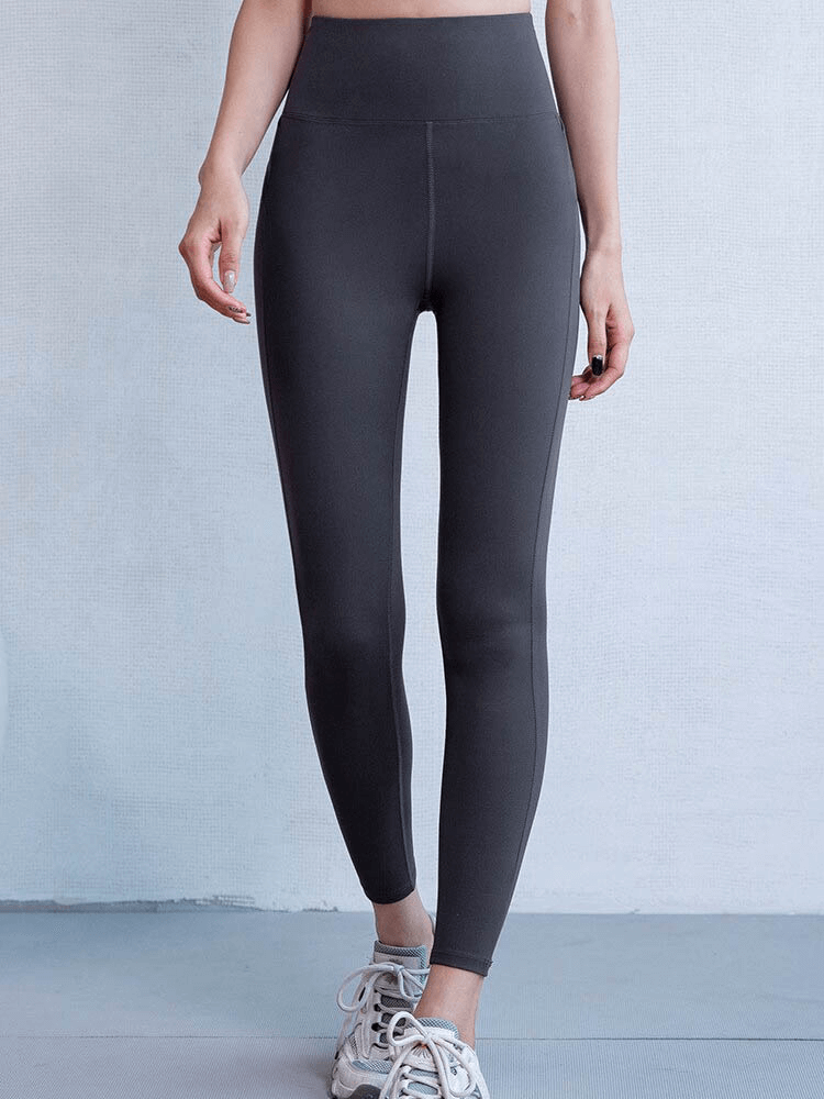 Woman wearing black seamless high waist leggings for sports, featuring a cross back and booty-lifting design, perfect for active wear.