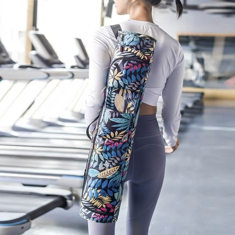 Woman carrying female-printed microfiber yoga mat bag with floral design in gym setting, showing stylish fitness gear solution.