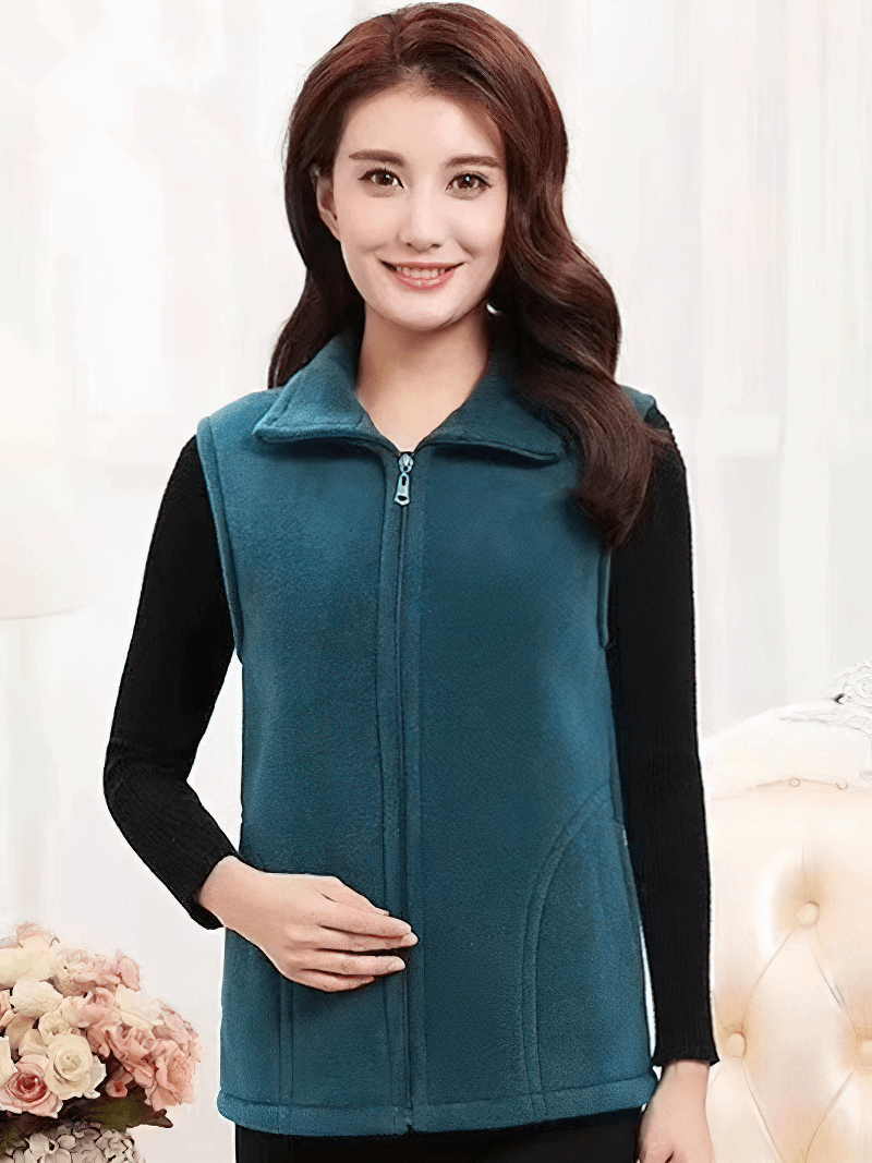 Woman wearing a teal fleece zip-up vest with pockets, perfect for warmth and style, featuring a turn-down collar.
