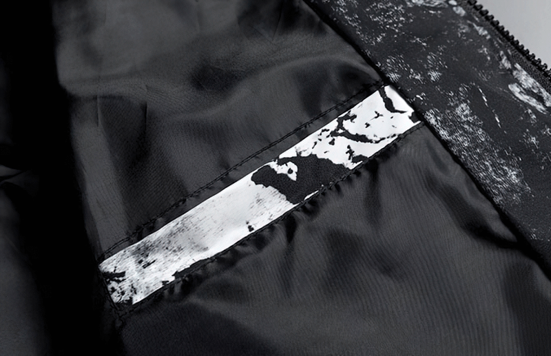 Close-up of black zipper hooded jacket with abstract print, showing lightweight polyester material and decorative pockets.