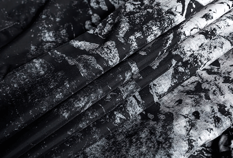 Close-up of abstract black and white print on lightweight fabric of a female zipper hooded jacket for a stylish look.