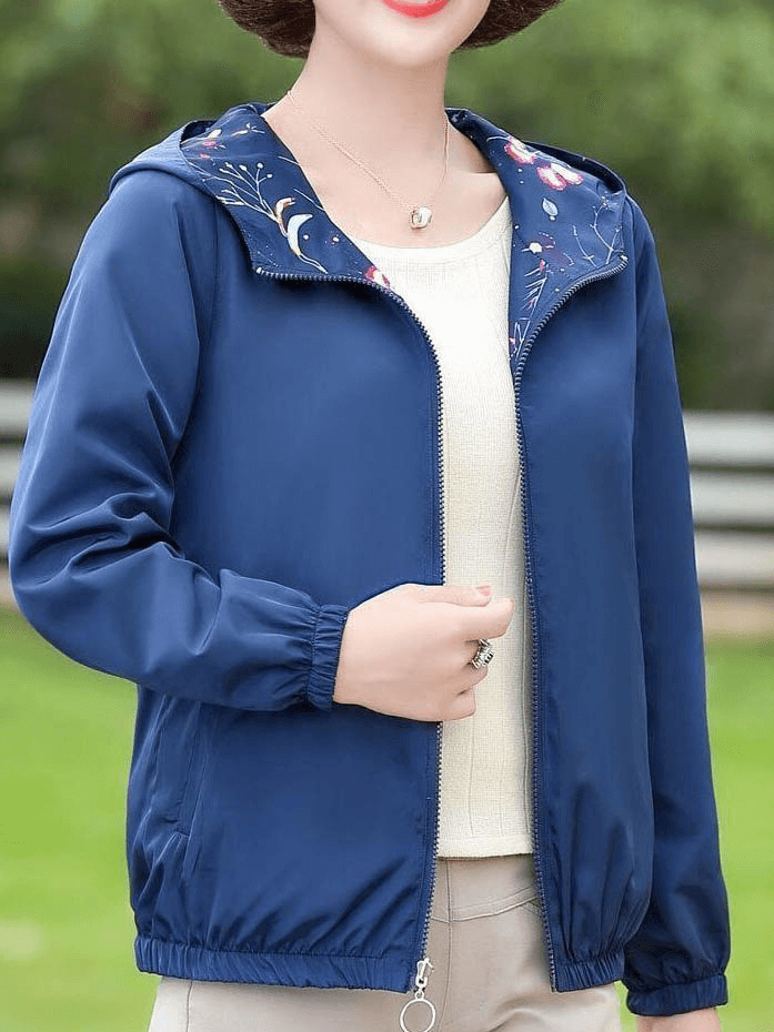 Stylish blue reversible windbreaker with floral hood, full sleeves, and zipper closure for women.