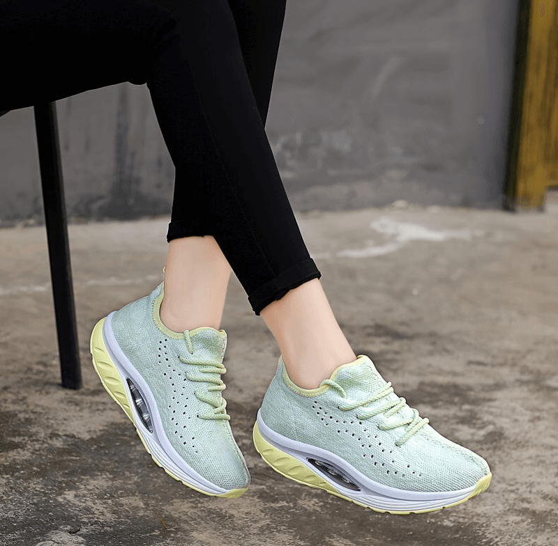 Woman wearing green lace-up platform sports sneakers with mesh upper for fitness and comfort.