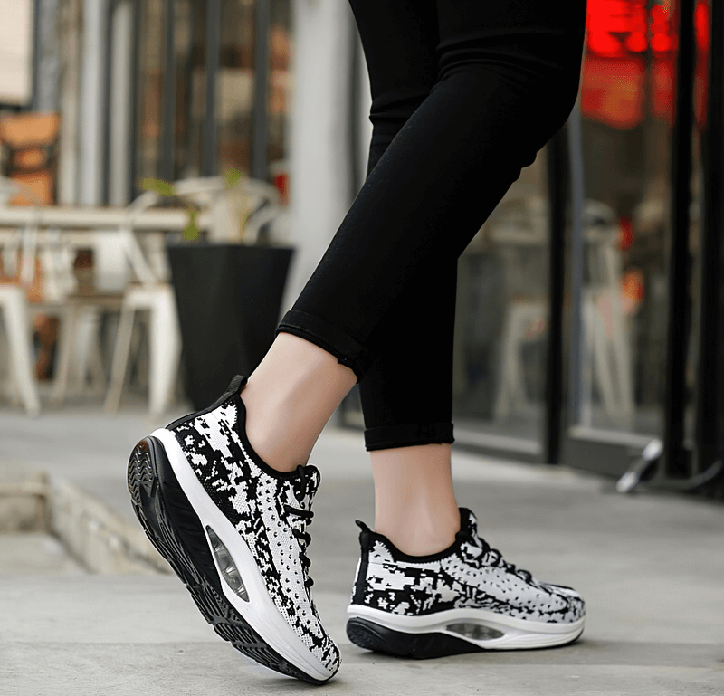 Woman wearing Fitness Lace-up Platform Sports Sneakers SF0253, showcasing stylish black and white design on an urban street.