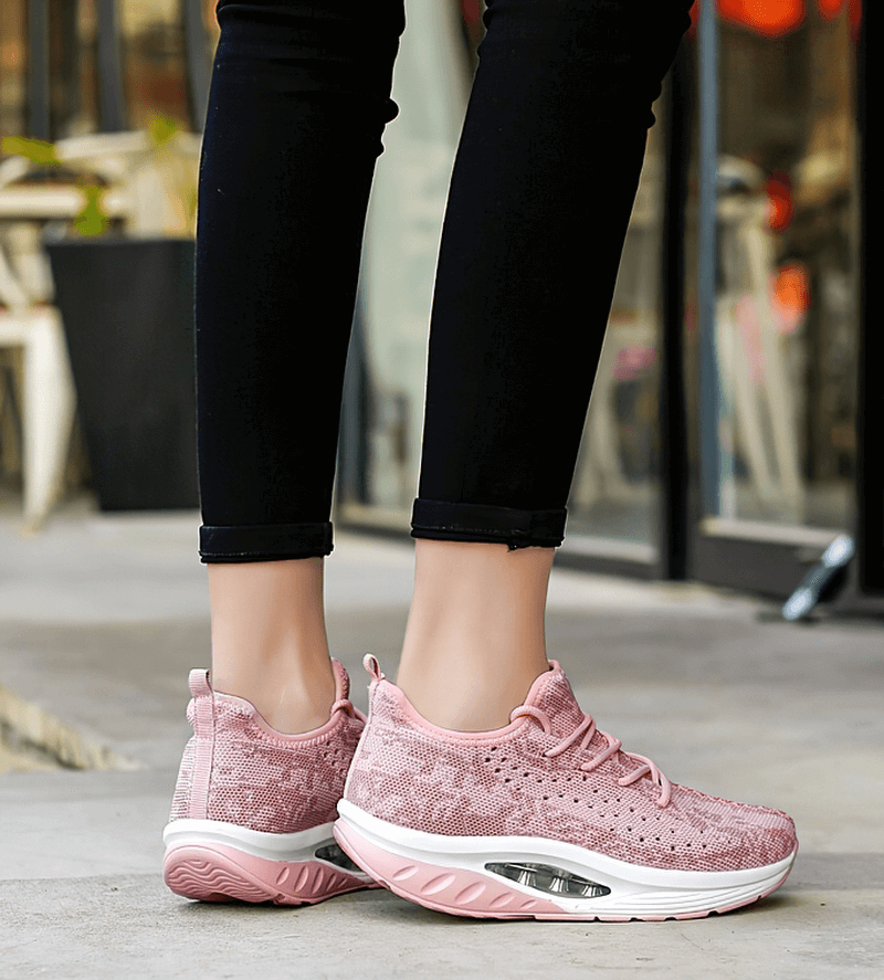 Stylish pink lace-up platform sports sneakers with breathable mesh upper, worn outdoors, perfect for fitness and everyday wear.
