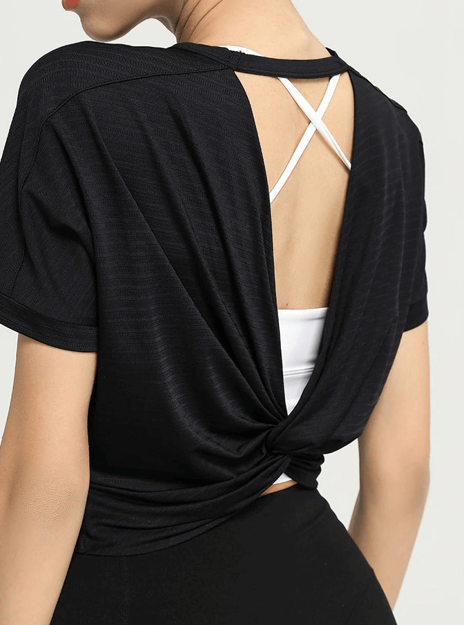 Back view of a black backless women's fitness T-shirt, perfect for yoga or the gym, featuring a stylish knotted design and full-length sleeves.