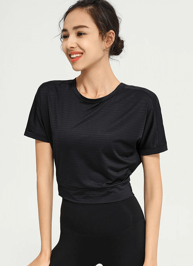 Woman wearing a black loose backless t-shirt perfect for yoga and gym workouts, showcasing stylish and comfortable sportswear.