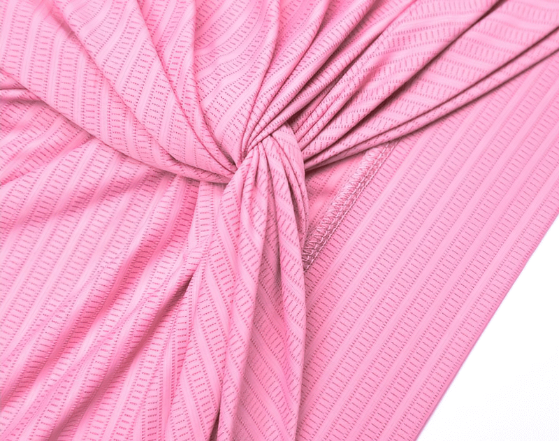 Close-up of pink textured fabric with an elegant twist knot design.
