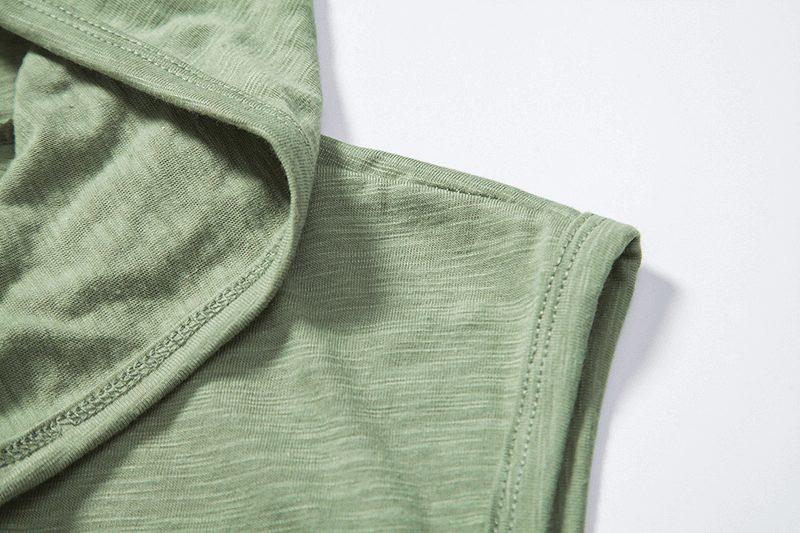 Close-up of green thin sleeveless hoodie fabric detail showcasing high-performance cotton blend.