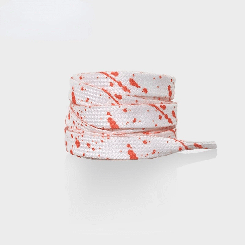 Flat colorful splatter-patterned shoelaces in white and red, perfect for sports shoes. Durable, unisex polyester laces. Model SF1130.