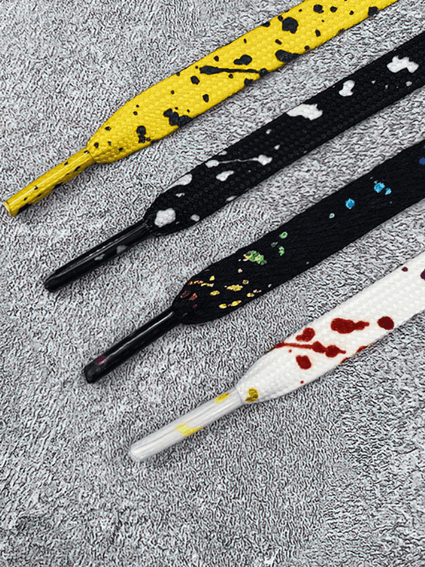 Colorful flat shoelaces in vibrant yellow, black, and white for sports shoes, SF1130, durable polyester material on gray background.