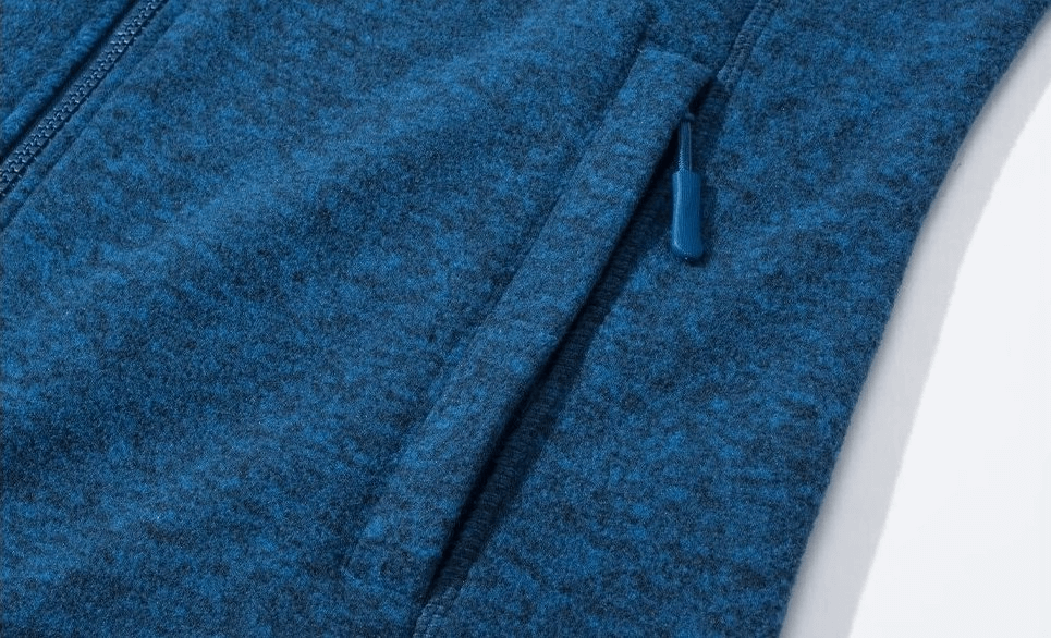 Close-up of blue fleece women's sweatshirt zipper and pocket for running, showcasing warm and stylish polyester design.