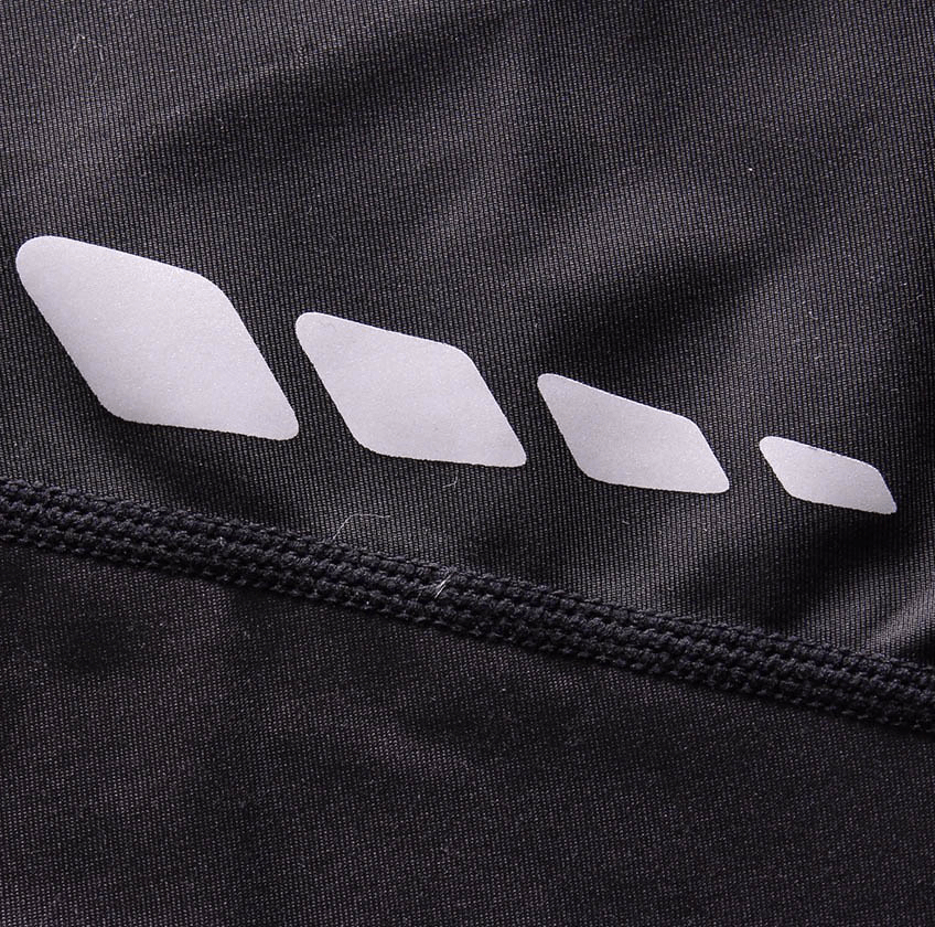 Close-up of black compression leggings with reflective detail, showcasing fabric quality and gym-ready design.
