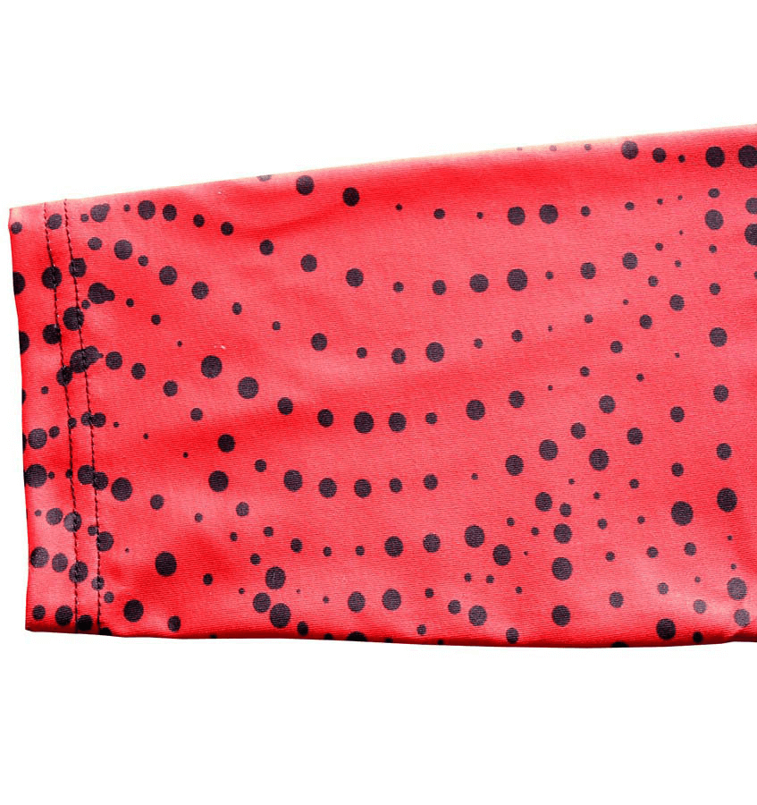 Close-up of red and black dotted high elastic compression leggings fabric.