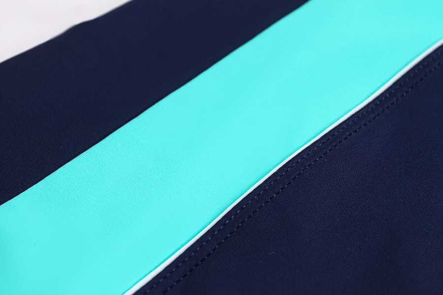 Close-up of high elastic one-piece swimsuit fabric in dark blue and light blue patchwork design.