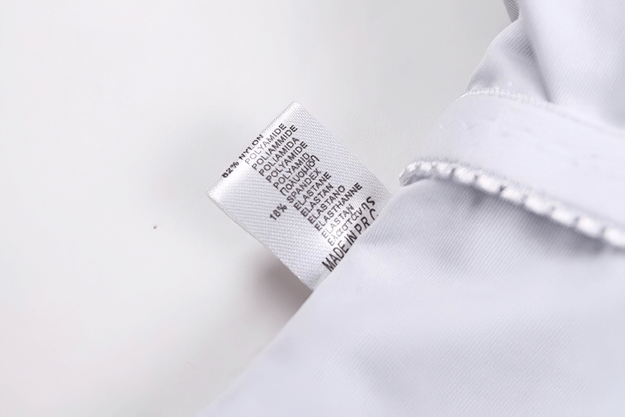 Close-up of swimsuit label showing fabric composition: 78% Polyamide, 22% Elastane, made in Brazil. Perfect for swimwear durability.