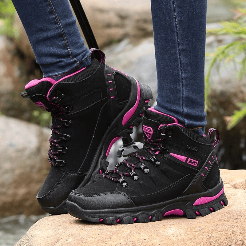 Women's mountaineering shoes with pink accents, perfect for hiking on rugged terrain, featuring breathable fabric and durable sole.