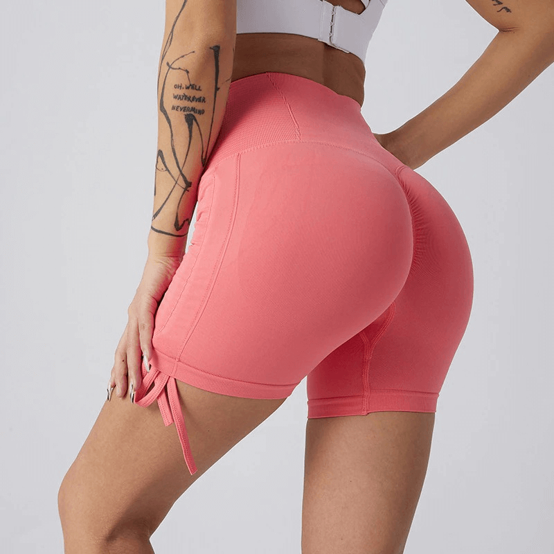Woman wearing high waist pink drawstring sports elastic shorts for yoga and fitness.