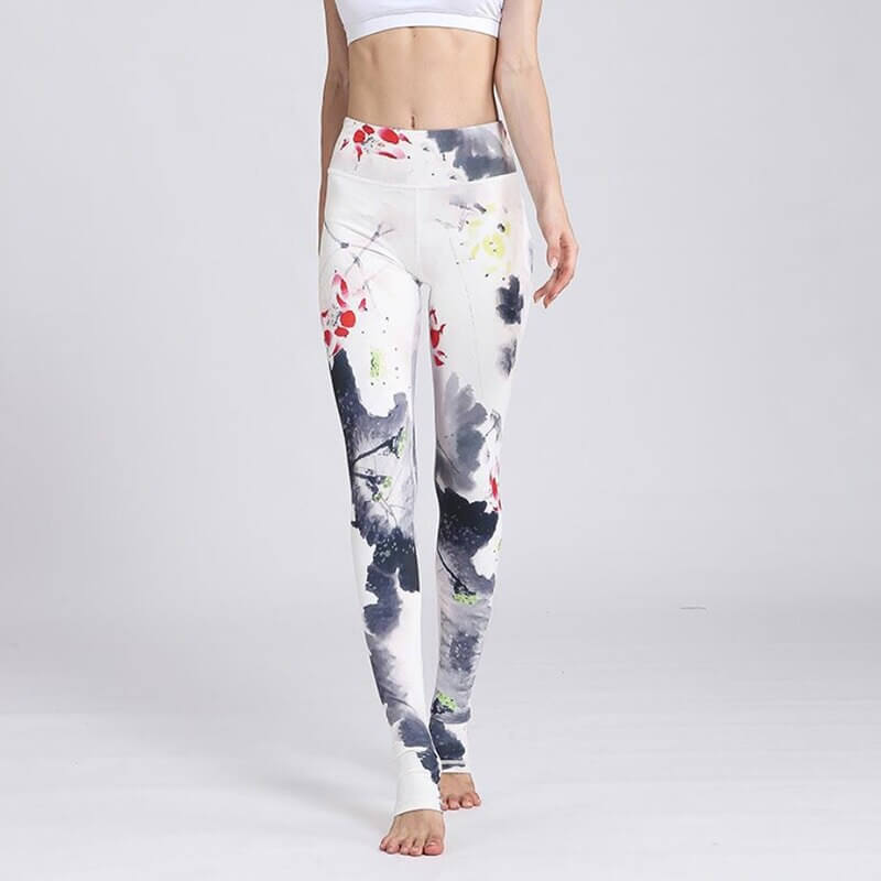 Woman wearing high waist sports leggings with floral prints, enhancing performance with flexible nylon-spandex fabric.