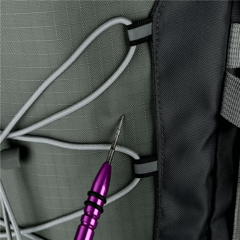 Close-up of water-resistant backpack fabric with elastic cord and purple tool, showcasing durability and design detail.