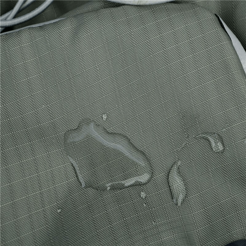 Close-up of water-resistant fabric on a hiking backpack showcasing droplets on its surface, highlighting its waterproof protection.