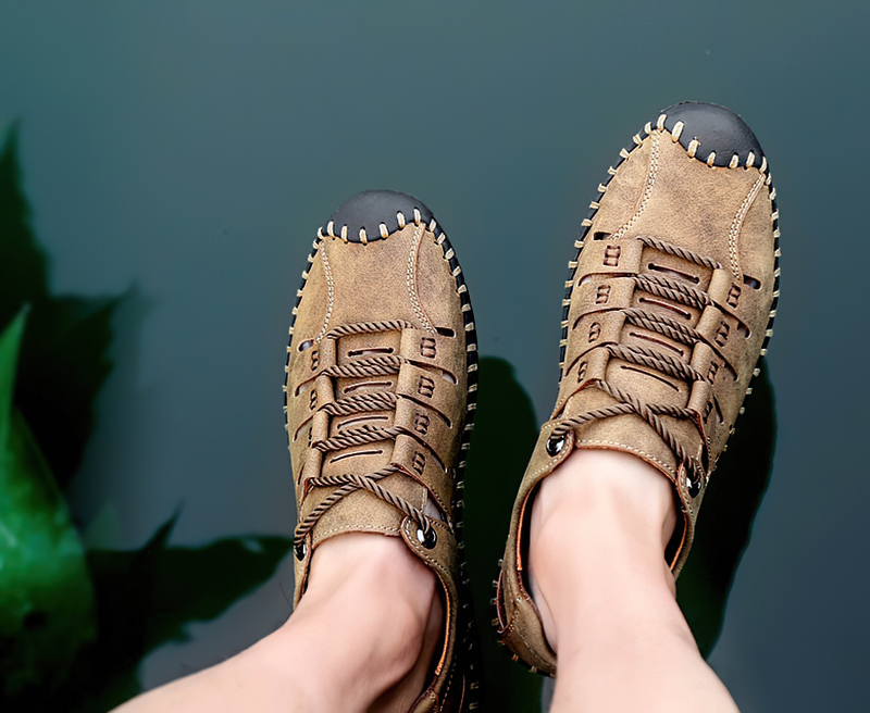 Person wearing lace-up leather sandals for men, ideal for outdoor activities; brown microfiber, PU leather, rubber outsole shown by water.