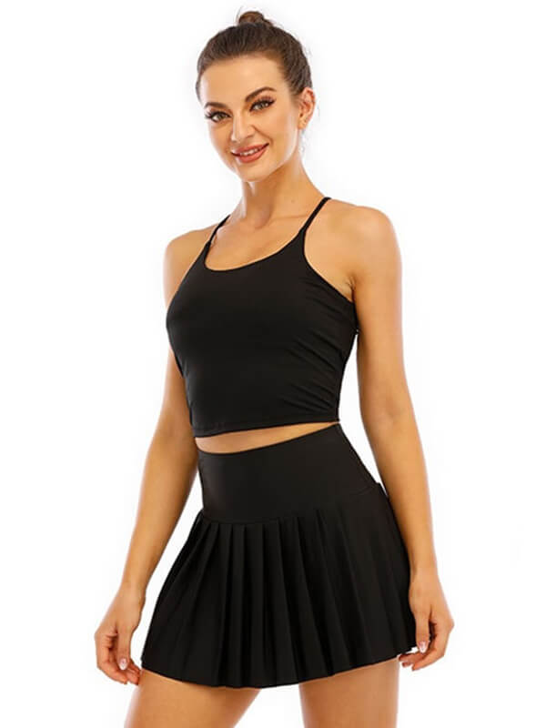 Woman wearing a black high waist pleated skirt for tennis, perfect for yoga and workouts, highlighting its elasticity and soft fabric.
