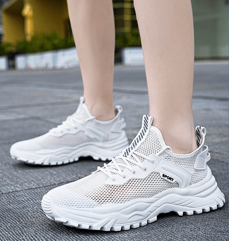 Person wearing white breathable sports sneakers with cushioning, perfect for running and athletics. Lightweight and comfortable design, model SF0704.