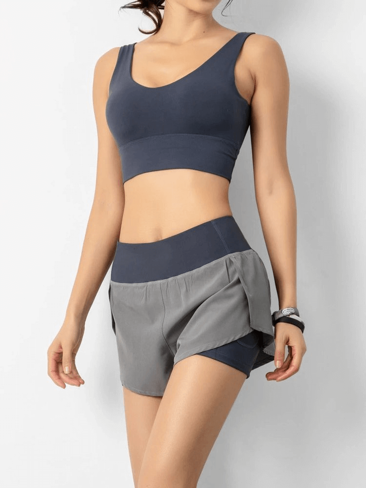 Woman wearing lightweight elastic quick dry shorts and sports bra, showcasing sporty design and comfortable fit, ideal for active wear.