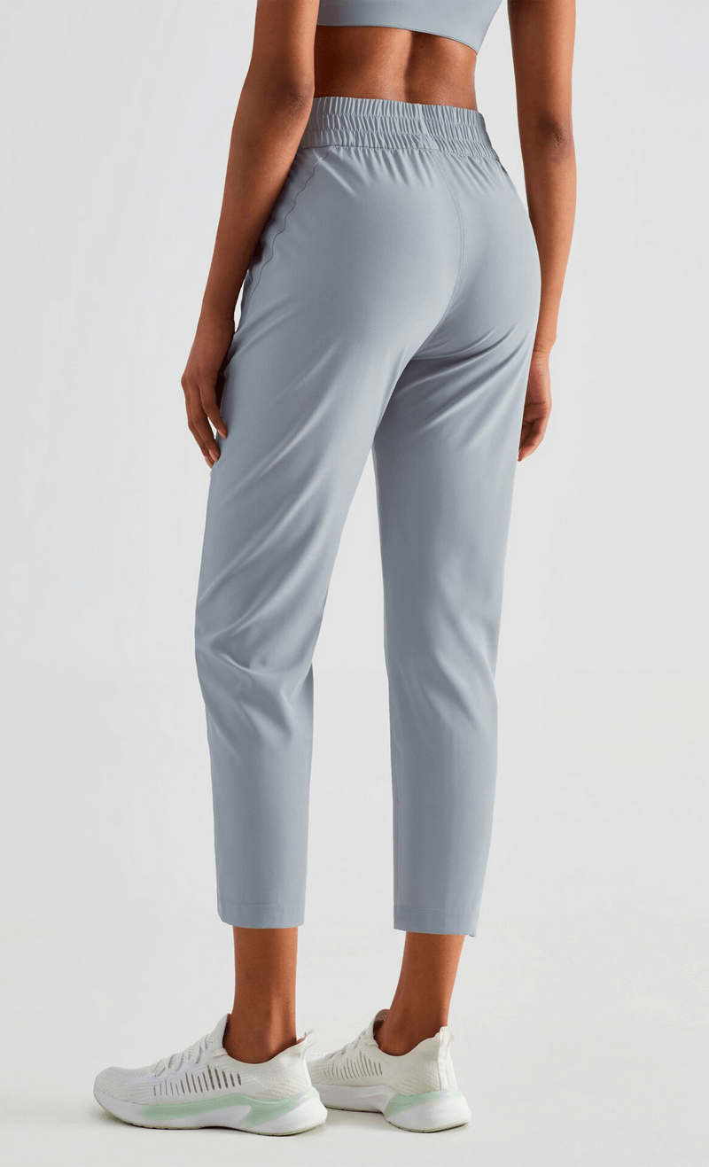 Woman wearing gray lightweight high waist fitness workout sweatpants with pockets, side view, showcasing comfort and style.