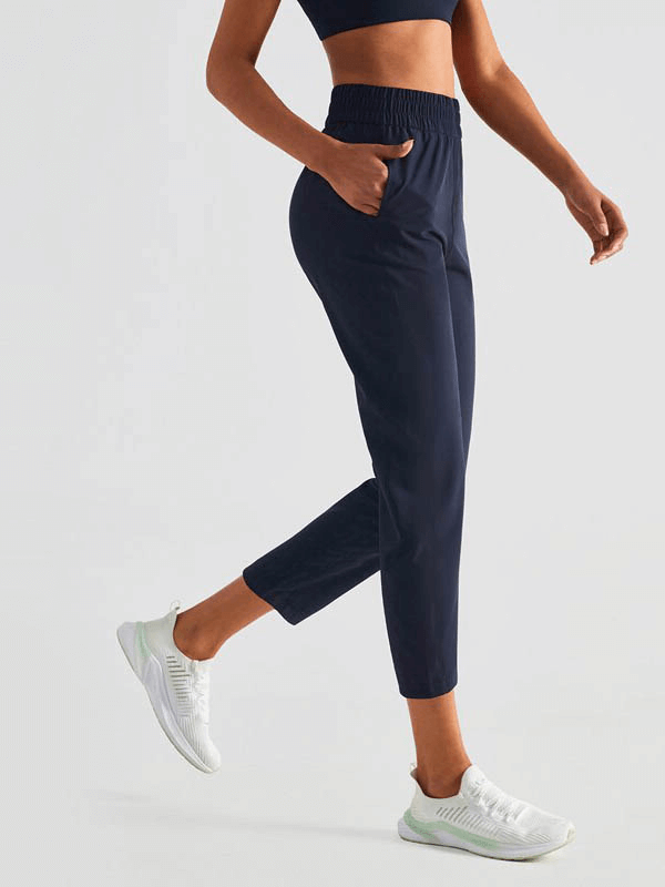 Person wearing high waist fitness workout sweatpants with pockets, showcasing comfortable elastic waistband and lightweight design.